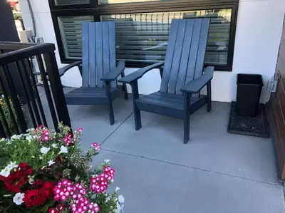 two blue chairs sitting on a porch with flowers at Modern luxury and convenience in Marda Loop in Calgary
