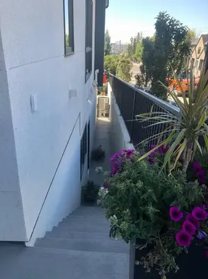a staircase leading to a building with purple flowers at Modern luxury and convenience in Marda Loop in Calgary