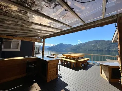 a deck of a boat with a table and benches at Private Ozarks Island Retreat in Agassiz