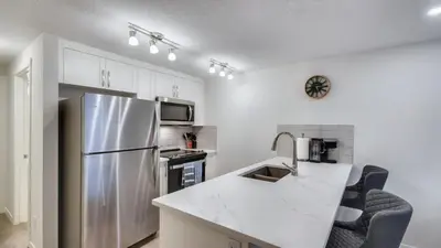 a kitchen with a refrigerator and a counter top at Cozy place to stay in south Calgary in Calgary