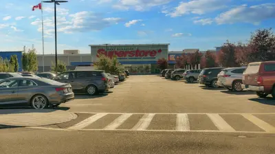 a parking lot with cars parked in front of a store at Cozy place to stay in south Calgary in Calgary