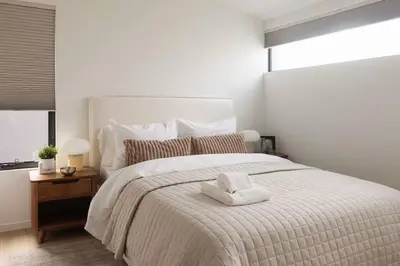 a bedroom with a white bed with a white towel on it at Casa Bramble Luxury 2Bed Suite near UofA Hospital in Edmonton