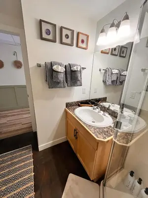 a bathroom with a sink and a mirror at Three Peaks Getaway Jacuzzi Suite - sleeps 4 in Canmore