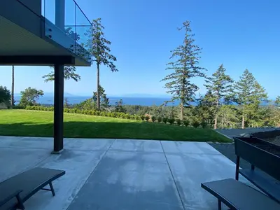 a patio with two benches and a view of the ocean at Winchelsea Views in Nanaimo