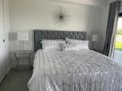 a bedroom with a large bed with a silver comforter at Winchelsea Views in Nanaimo