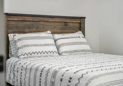a bed with white sheets and pillows at Mountain Hideaway Two Bedrooms Free Park Pass in Cochrane