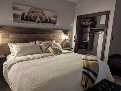 a bedroom with a large bed with a picture of a bear at Skyline Suite 2Bdrm King in Valemount