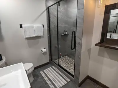 a bathroom with a shower with a toilet and a sink at Skyline Suite 2Bdrm King in Valemount
