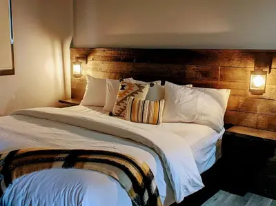 a bedroom with a large bed with a wooden headboard at Skyline Suite 2Bdrm King in Valemount