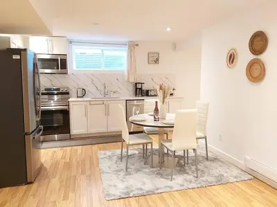 a kitchen with a table and chairs and a refrigerator at Cozy suite, Free WIFI , Free Parking in Calgary