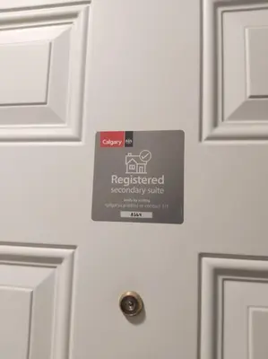 a house door with a sign on it at Cozy suite, Free WIFI , Free Parking in Calgary