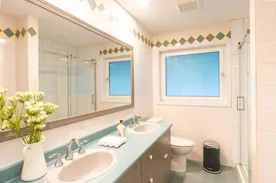 a bathroom with two sinks and a mirror at Beaver Beach Vacation Home in Madeira Park