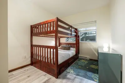 a bedroom with two bunk beds and a television at Deer Run by Outpost Whistler in Whistler