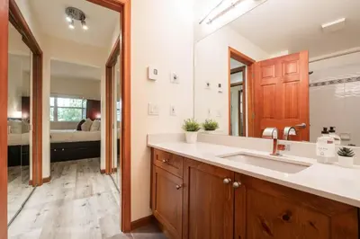 a bathroom with a sink and a large mirror at Deer Run by Outpost Whistler in Whistler