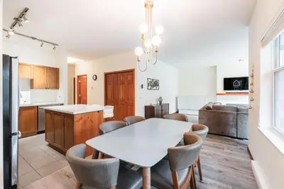a kitchen and dining room with a white table and chairs at Deer Run by Outpost Whistler in Whistler