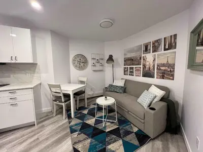 a living room with a couch and a table at Serenity 1BR & 1 DEN Home at Folsom Ave in Coquitlam