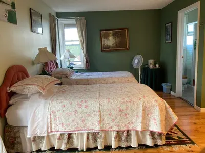 a bedroom with a bed and a window and a fan at Tudor House Bed and Breakfast in Bottrel