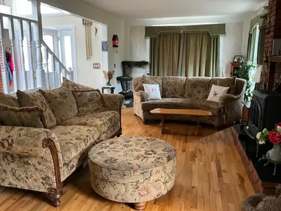 a living room with a couch and a chair and a stool at Tudor House Bed and Breakfast in Bottrel