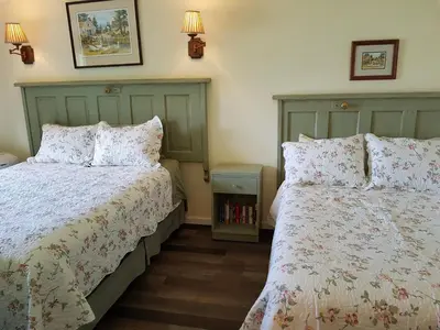a bedroom with two beds and a night stand at West facing Waterfront Cottage with private beach & buoy & dock access in Blind Bay