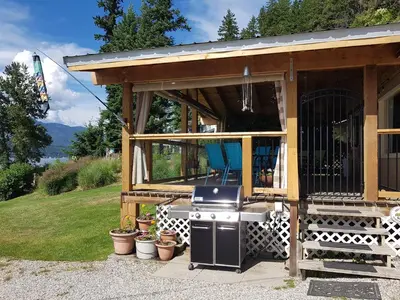 a tiny house with a stove and a grill at West facing Waterfront Cottage with private beach & buoy & dock access in Blind Bay