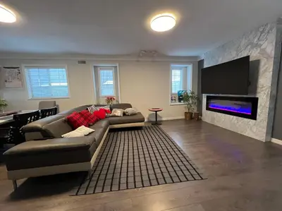 a living room with a couch and a flat screen tv at Vancouver Airport 7 mins away Cozy room Richmond near YVR in Richmond