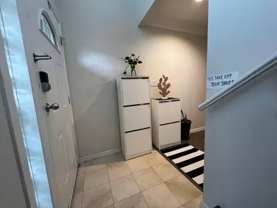 a hallway with a white cabinet with a plant on it at Vancouver Airport 7 mins away Cozy room Richmond near YVR in Richmond