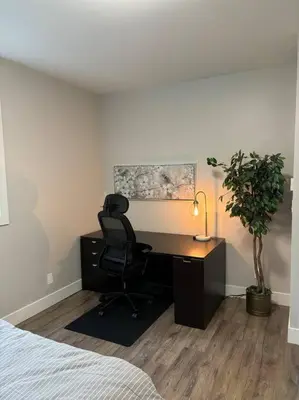 a bedroom with a desk with a chair and a plant at Executive 1 Bedroom Lakeview Retreat in Shawnigan Lake