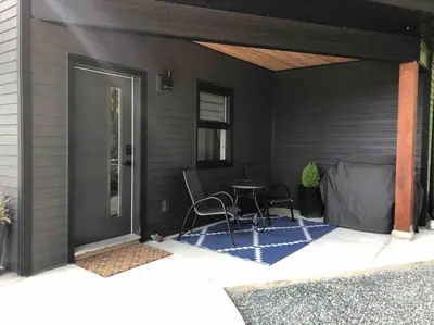 a patio with a table and chairs in a house at Executive 1 Bedroom Lakeview Retreat in Shawnigan Lake