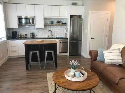 a kitchen and living room with a couch and a table at Executive 1 Bedroom Lakeview Retreat in Shawnigan Lake