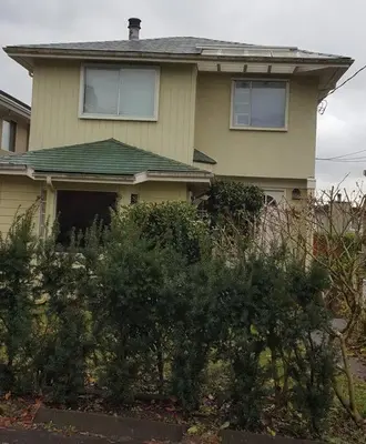 a house with a lot of bushes in front of it at Bright 2 BR, Great Location in West Vancouver