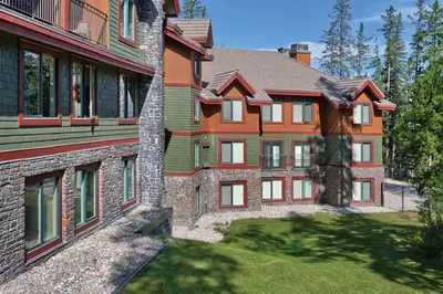 a large house with a grass yard in front of it at Worldmark Canmore Banff Alberta Canada in Canmore