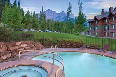 a large swimming pool with chairs and a building at Worldmark Canmore Banff Alberta Canada in Canmore