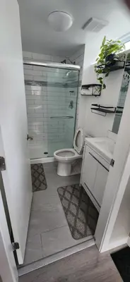 a bathroom with a shower and a toilet and a sink at The Bainbridge Studio in Burnaby