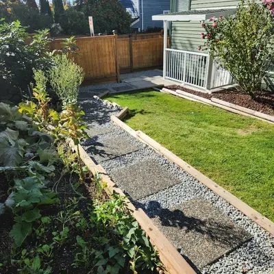 a backyard with a garden with grass and rocks at The Bainbridge Studio in Burnaby