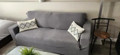 a gray couch with pillows in a living room at The Bainbridge Studio in Burnaby