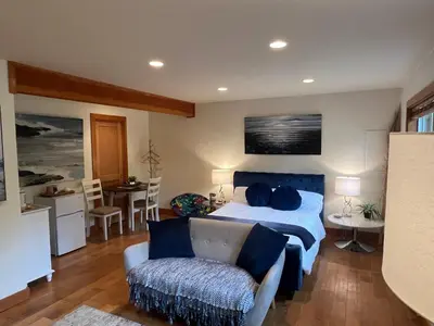 a bedroom with a bed and a couch and a chair at A Seaside Jacuzzi Escape in Parksville, BC, Canada in Parksville