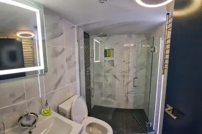 a bathroom with a shower and a toilet and a sink at Upscale Modern Apartment in Whistler