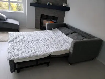 a bed in a living room with a fireplace at Upscale Modern Apartment in Whistler