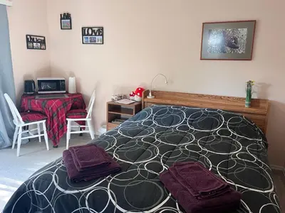 a bedroom with a bed and a desk with a computer at Serenity Bed and Breakfast in Comox