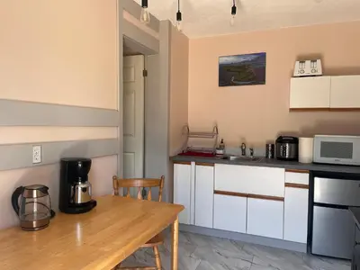 a kitchen with a wooden table and a counter top at Serenity Bed and Breakfast in Comox