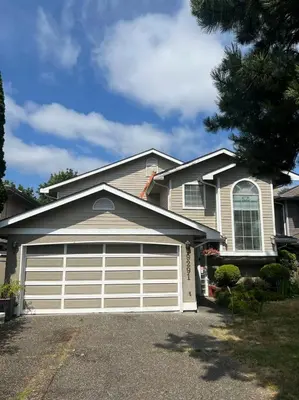 a house with a white garage door at Vancouver airport 7mins away joy room in Richmond