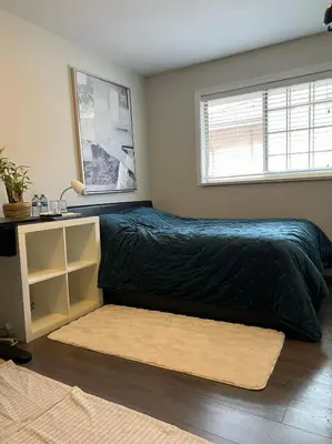 a bedroom with a bed with a black comforter and a window at Vancouver airport 7mins away joy room in Richmond