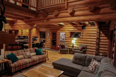 a living room with couches in a log cabin at GrizzPaw Lodge - Mountain Resort - 5 Bedroom Chalet - Sleeps 14 People in Golden