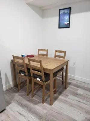 a wooden dining room table with four chairs at Entire guest suite in Cochrane, AB in Cochrane