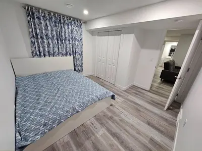 a small bedroom with a bed and a closet at Entire guest suite in Cochrane, AB in Cochrane