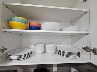 a shelf with plates and bowls in a kitchen at Entire guest suite in Cochrane, AB in Cochrane