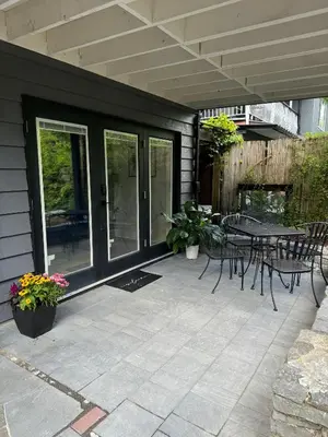 a patio with a table and chairs on a house at Spacious Forested Garden Suite in North Vancouver