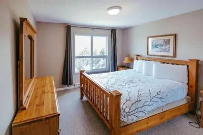 a bedroom with a large bed and a window at Peaks of Radium by StayIn in Radium Hot Springs