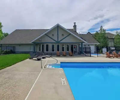 a house with a swimming pool in front of a house at Peaks of Radium by StayIn in Radium Hot Springs