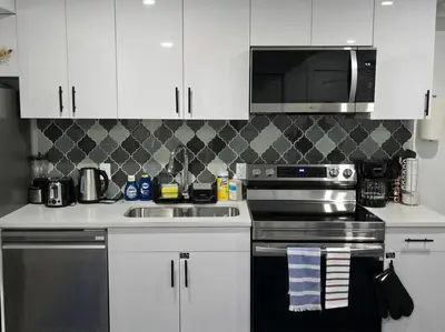 a kitchen with a stove and a sink and a microwave at Cozy New 1 bed basement suite in Edmonton